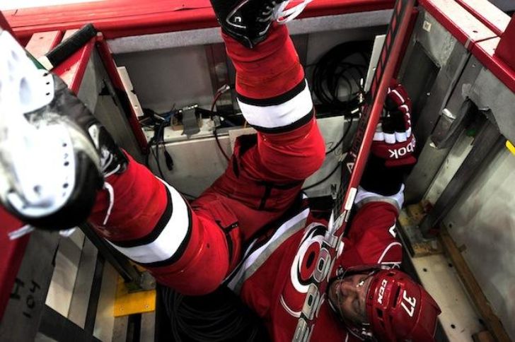 Hockey player falling into penalty box