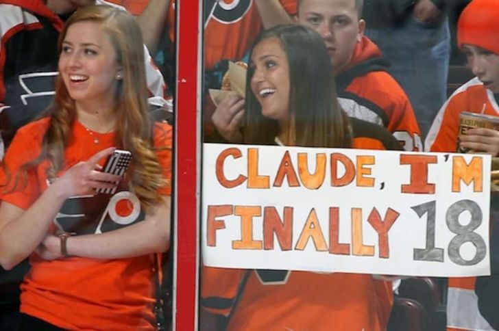 Fans with sign about being of legal age at hockey game