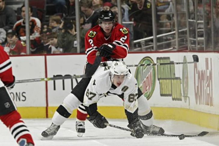 Hockey players colliding, one riding on another