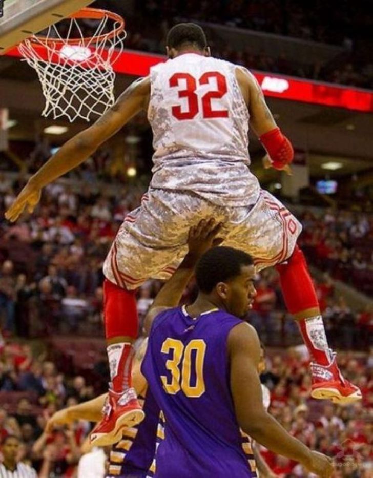 Basketball players in awkward midair tangle